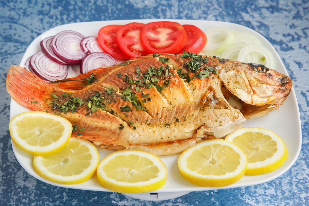 Grilled fish plated with lemon